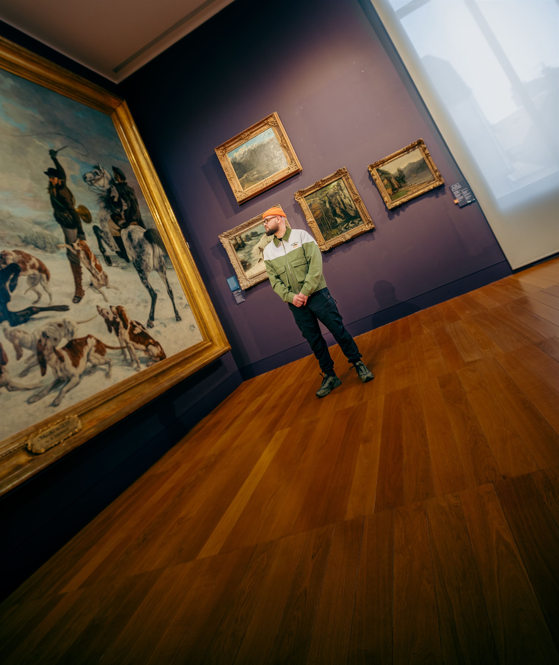 Plan large dans une salle de musée, tableaux anciens et parquet